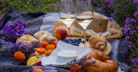 picnic in a lavender field, rest in nature, wine, fruit, berries.