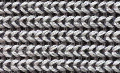 Close-up of a fragment of knitted sweater. Natural gray wool textile background from knitted stripes. Warm knitted cozy clothes. Flat lay, macro, top view, mockup