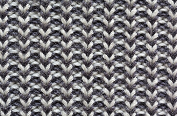 Close-up of a fragment of knitted sweater. Textile background from loops of gray and white wool from knitted stripes. Warm knitted cozy clothes. Flat lay, macro, top view, mockup