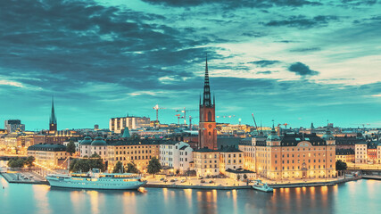 Fototapeta na wymiar Stockholm, Sweden. Scenic View Of Stockholm Skyline At Summer Evening. Famous Popular Destination Scenic Place In Dusk Lights. Riddarholm Church Day To Night Transition