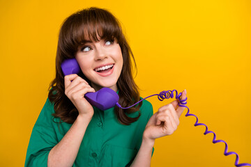 Photo of dreamy girly lady wear green shirt speaking phone looking empty space isolated yellow...
