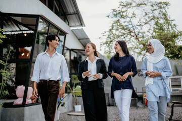 Group of cheerful young businesspeople discussing working together on a new project while standing at an outdoor workplace