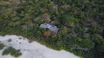House in the forest. Aerial view of the roof of a small house among the jungle near the beach.