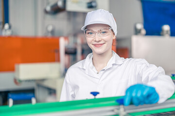 Happy teen young women worker in conveyor belt production line in food and beverage factory with employee white hygiene clothes