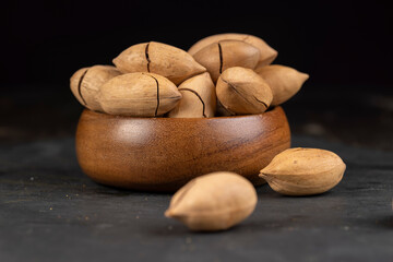 unpeeled pecans in a shell on the kitchen table