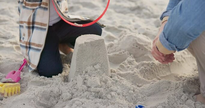 Hands, family and child with sand castle at beach for holiday, vacation or bonding fun. Man playing with girl and bucket toys for quality time, travel adventure and building for development at sea