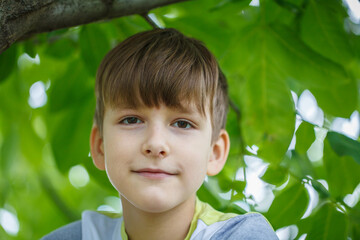 caucasian boy nine years old looking at the camera standing on the street. close-up