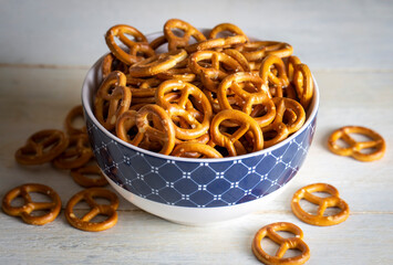 Mini pretzels with salt on wooden background. Selective focus.