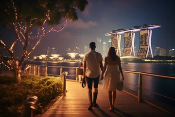 Selbstklebende Fototapeten Young couple traveling and walking in Singapore. City in background. Man and woman view from behind. Sunset summer background. Generative AI © Rytis