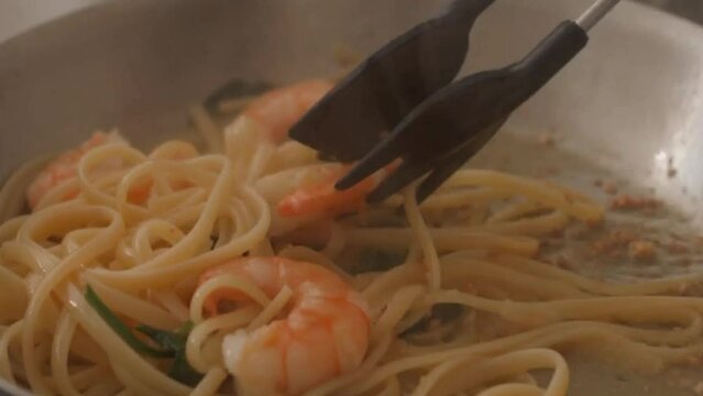 Closeup of cooking garlic prawn spaghetti in a frying pan	