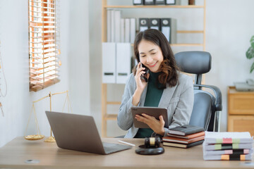 Obraz premium Portrait of Asian woman talking mobile phone and working on laptop and calculator on table in office.