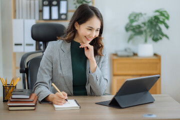 Office worker lifestyle people. Woman writing notes on book and using laptop. home office workplace lifestyle people.