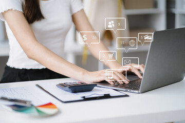 Female fashion designers use smart phones and use laptops with digital tablet computers to get orders from customers.