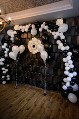 Black photo zone with balloons and flowers on birthday party