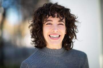 Pretty young woman with short hair smiling outside