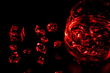 Glass with cognac and ice on a dark background. the concept of alcoholism and drinking