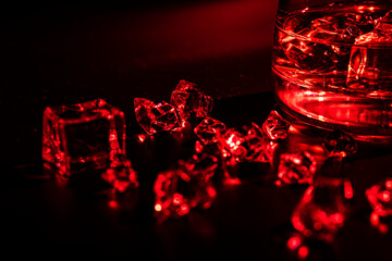 Glass with cognac and ice on a dark background. the concept of alcoholism and drinking