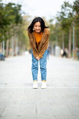 Full body smiling young asian woman standing