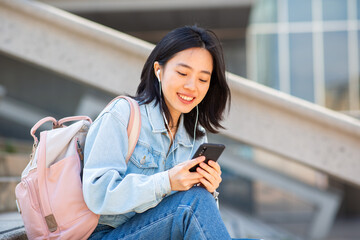 young asian woman sitting with cellphone