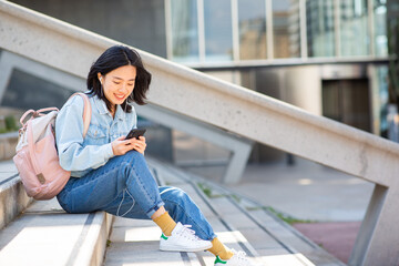 smiling young woman sitting with mobile phone