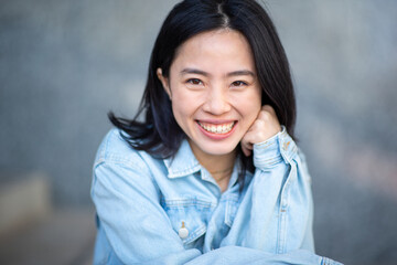 young asian woman smiling and looking at camera