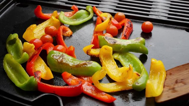 Cooking sweet bell peppers and tomato on grill, barbeque. Slow motion