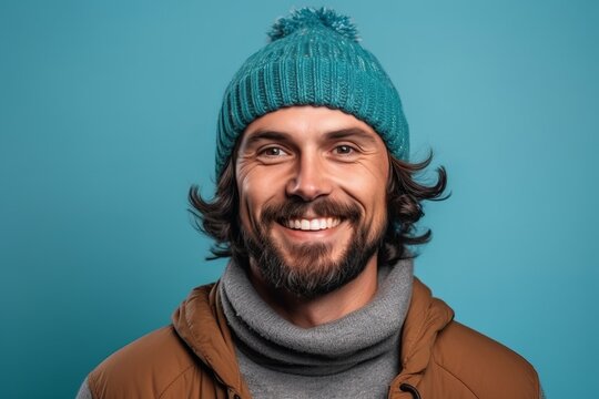 Portrait Of A Smiling Man In Winter Hat And Coat Looking Away Isolated Over Blue Background