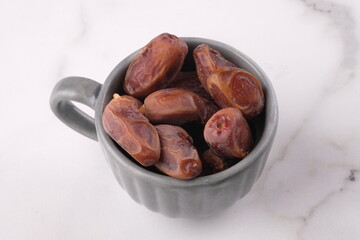 stalked dates on a gray cup. Ramadan iftar dishes. kurma tangkai. Tunisian dates. Deglet Nour Dates.