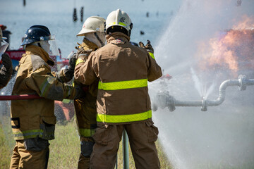 Firefighters and rescue training. Firefighter spraying high pressure water to fire Burning fire...