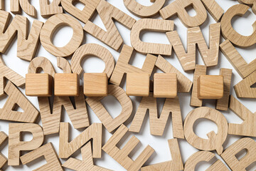 Wooden letters and cubes on white background, top view