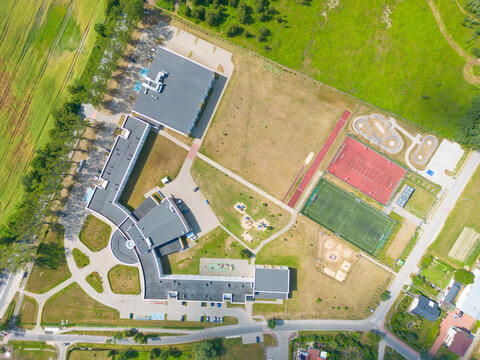 school sports ground with football stadium, jogging tracks around. basketball, volleyball, tennis courts. aerial photo, top view.