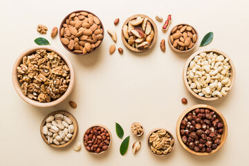 mixed nuts in wooden bowl. Mix of various nuts on colored background. pistachios, cashews, walnuts, hazelnuts, peanuts and brazil nuts