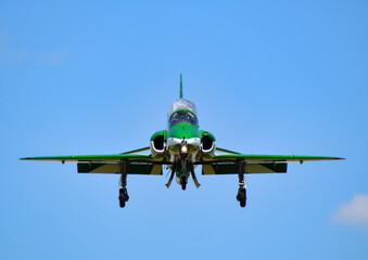 single green saudi Hawks falcons aerobatic team fighter jet face on coming in to land with blue...