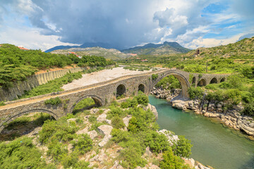 Drone view of the Mesi Bridge, located in Albania, is an architectural gem that spans the Kir River in the picturesque village of Mesi. This historic stone bridge, dating back to the Ottoman period.