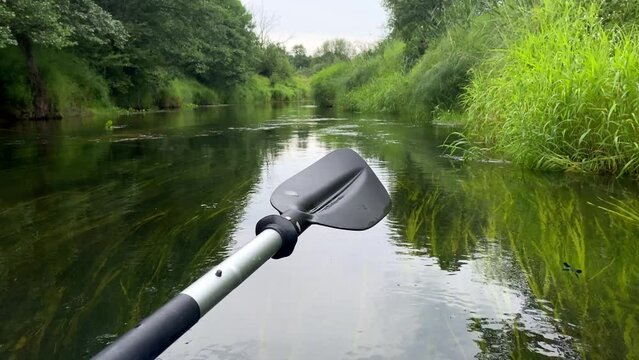 Close-up of plastic paddle over water on river in summer.
