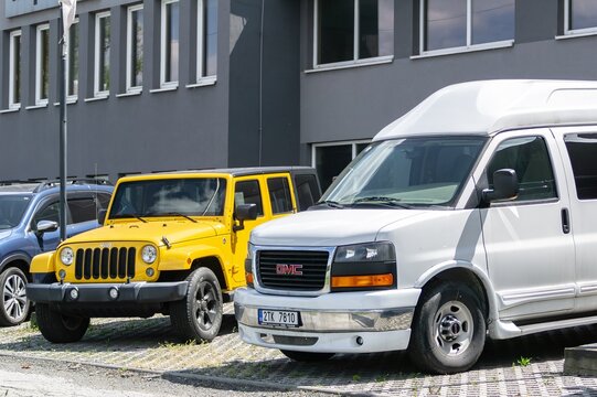 GMC Savana Passenger Van And Jeep Wrangler SUV In Front Of Dealership In Ostrava