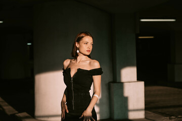 sexy attractive woman in black evening dress in sunlight posing. Beautiful elegant woman model beauty standard