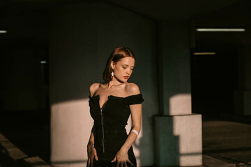 Naklejka premium sexy attractive woman in black evening dress in sunlight posing. Beautiful elegant woman model beauty standard