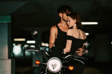 Fototapeta na wymiar sexy couple in love on a motorcycle. Love of a man and a woman and a motorcycle