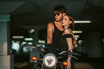 Obraz premium sexy couple in love on a motorcycle. Love of a man and a woman and a motorcycle