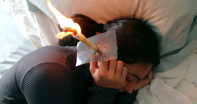 Person applying ear candling to remove ear wax