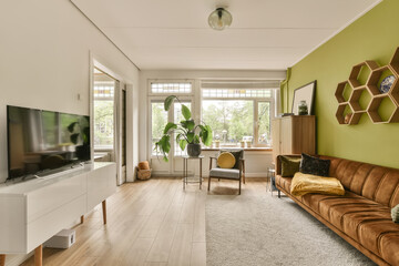 a living room with green walls and white trim on the walls, an orange couch is in the center of the room