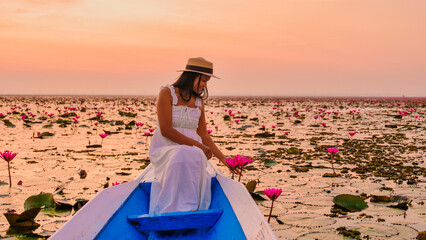 Asian women in a boat at the Beautiful Red Lotus Sea Kumphawapi is full of pink flowers in Udon...