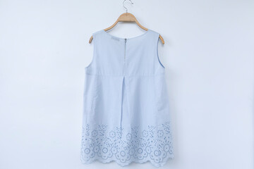Blue blouse is on clothes-hanger on white background.close up.