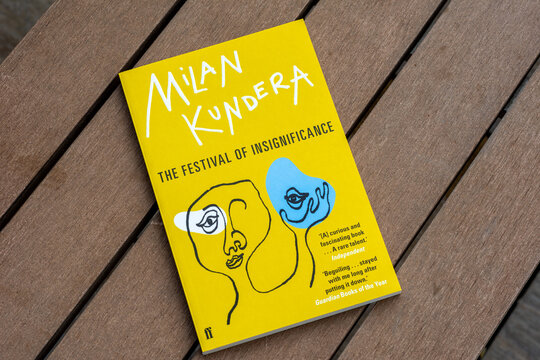 Close up Milan Kundera's The Festival of Insignificance novel on the wooden table.