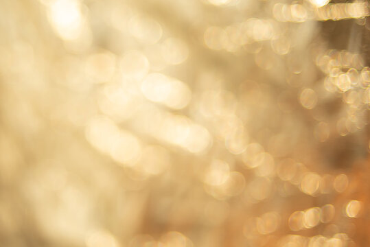 Abstract blurred background with highlights and bokeh. Golden background of glitter