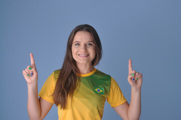 torcedora sorridente com camisa do brasil apontando para anúncio ou promoção, brasil no esporte...