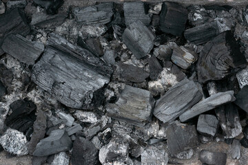 Black coal as natural background with copy space. . Wooden burnt pieces as fuel for warming