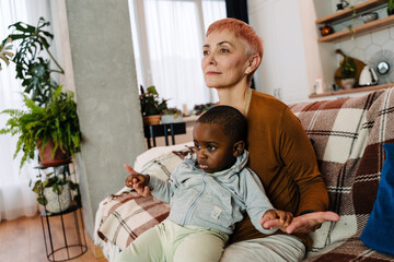 Mature woman sitting on couch with her adopted son