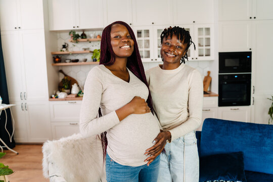 Black pregnant woman smiling while spending time with her girlfriend